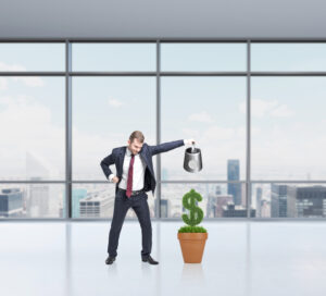 businessman watering money to signify growth