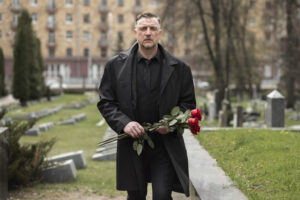 man at cemetery with roses